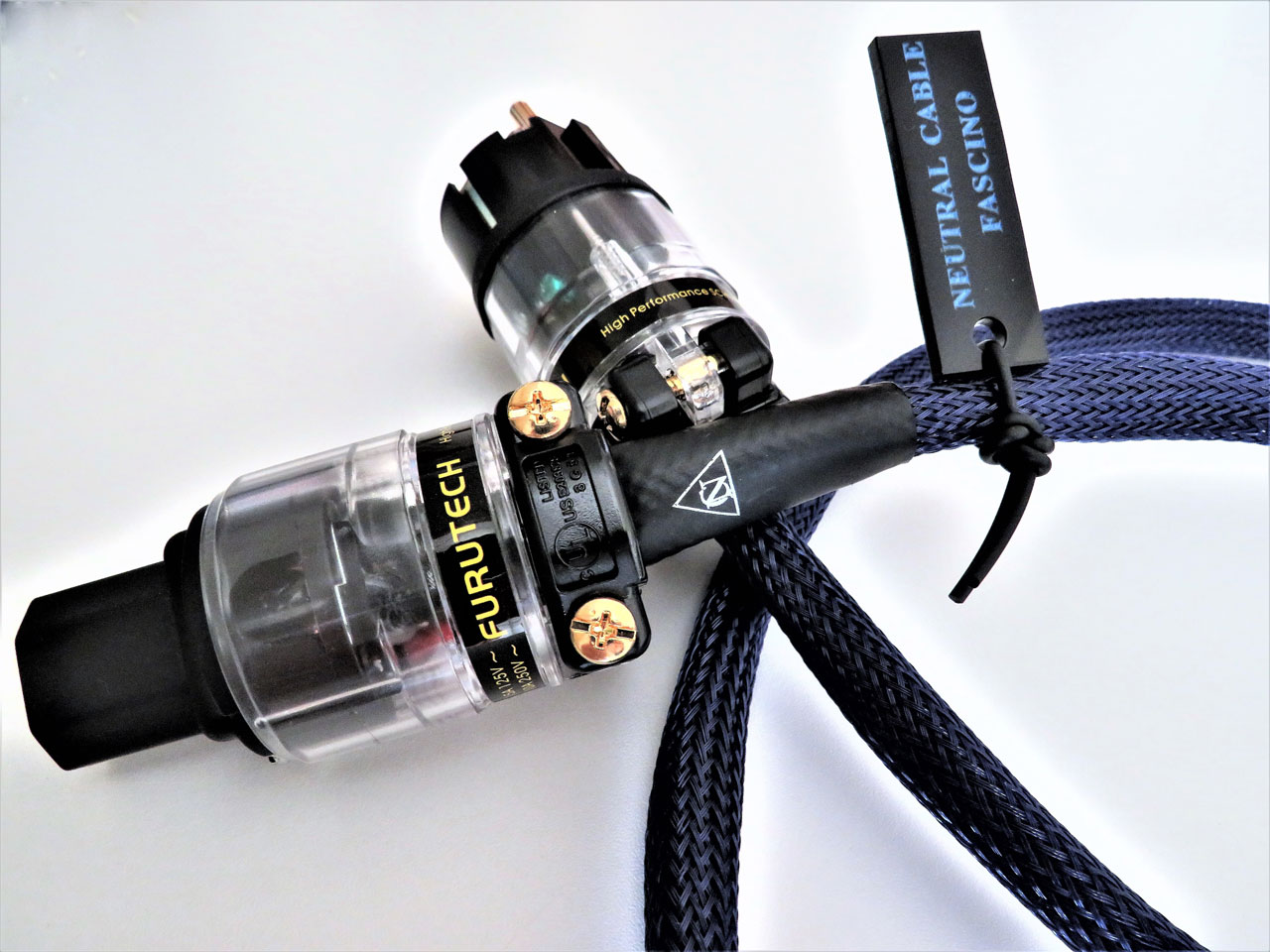 Cavi audio hi-fi con connettori Furutech, particolare di alta gamma GF: connettori placcati e corpo trasparente, etichetta 'FURUTECH' e fascette. alt text per SEO: Cavi audio hi-fi Furutech di alta gamma con connettori, dettaglio targhetta Nero/blue. Cavi di alimentazione audiofili hi-fi con connettori Furutech: dettaglio di alta gamma, cavo intrecciato blu e etichetta sul morsetto.